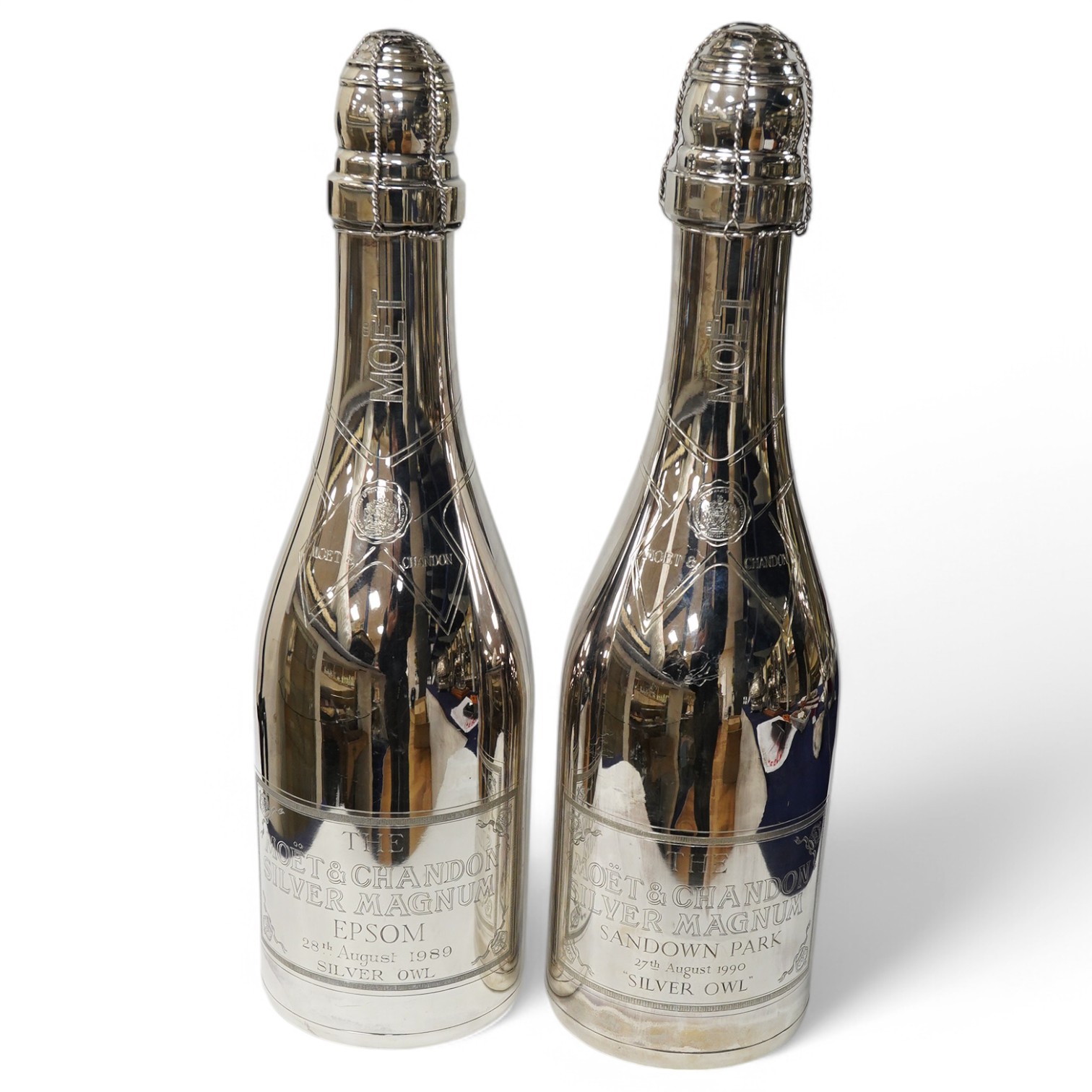 A near pair of Elizabeth II silver presentation magnum bottles by Garrard & Co inscribed 'Moet & Chandon Silver Magnums, Epsom 28th August 1989' and 'Sandown Park, 27th August, 1990', both won by 